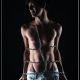 tied up with a chain, portrait de studio avec un jeune homme enchainé, torse nu en pantalon blanc, musclé - unartvisuel de Genève. Annuaire photographe