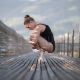 Danseuse de ballet accroupie en pointe sur un vieux pont en bois au levé du soleil - fredvaudroz de Montreux. Annuaire photographe